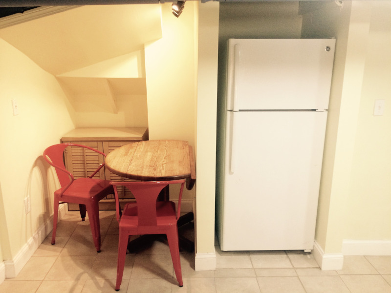 Refrigerator next to kitchen table in eating nook